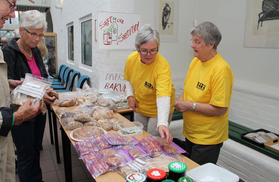 Haldis Nedrelid (gul t-skjorte til venste) og Ruth Løvdahl er to av dei mange gulkledde som gjer ein innsats under kyrkjetundagane. Her sel dei heimebakst. Foto: Grethe Hopland Ravn