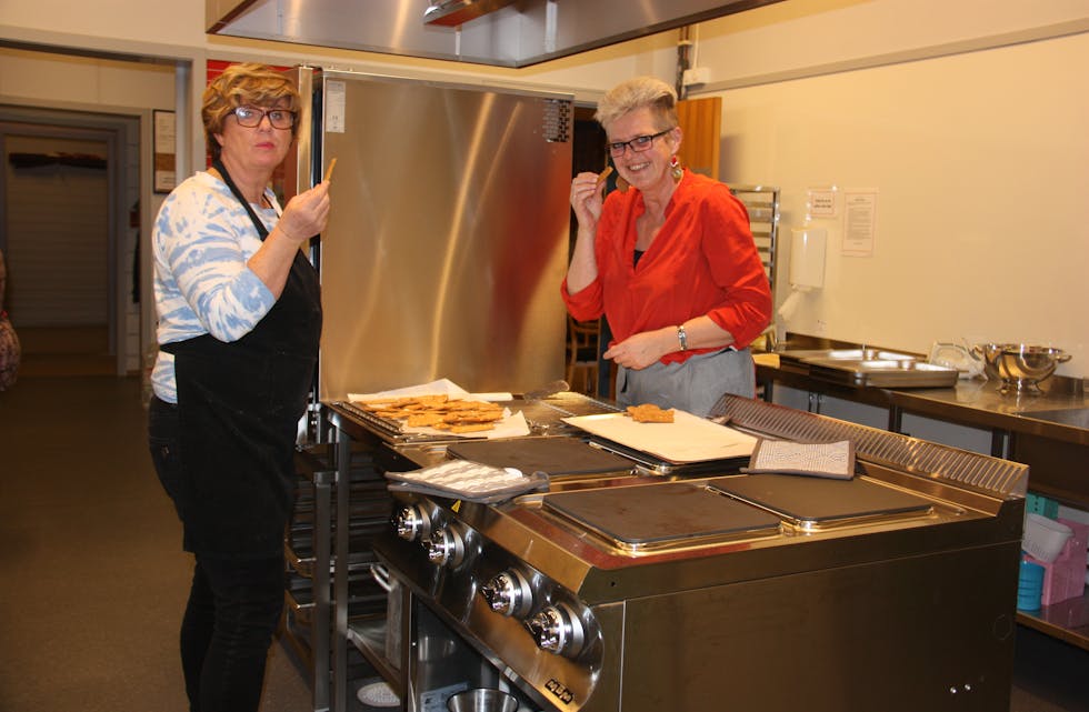 Grete Helgesen (t.v.) og Gunn Vikingstad smakar på julekakene som er bakt på det kjøkkenet på bygdehuset. Foto: Irene Mæland Haraldsen