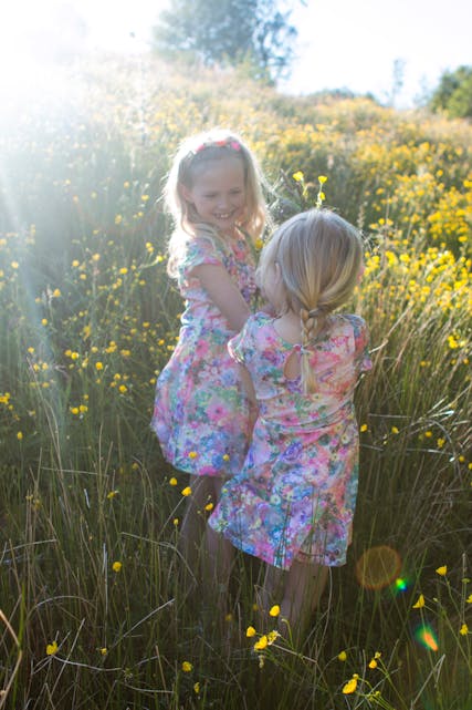 Søstrene Linnea og Avienda plukkar blomster i ei fin blomstereng. Foto: Vibeke Klundland Opheim