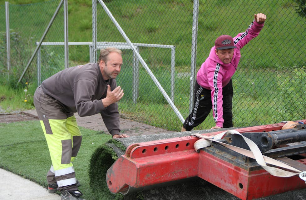 Jan Egil Søndenå (t.v) samarbeidar med Robert frå Unisport i Kristiansand, for å få siste rest med kunstgras på rull. 
Foto: Grethe Hopland Ravn