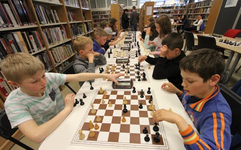 Albert Rafdal og Karolis Morkonas konsentrert i eit parti sjakk under turneringa i Etne. Mange unge brukar biblioteket til å spele sjakk etter skuletid. Foto: Jon Edvardsen