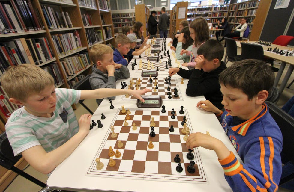 Albert Rafdal og Karolis Morkonas konsentrert i eit parti sjakk under turneringa i Etne. Mange unge brukar biblioteket til å spele sjakk etter skuletid. Foto: Jon Edvardsen
