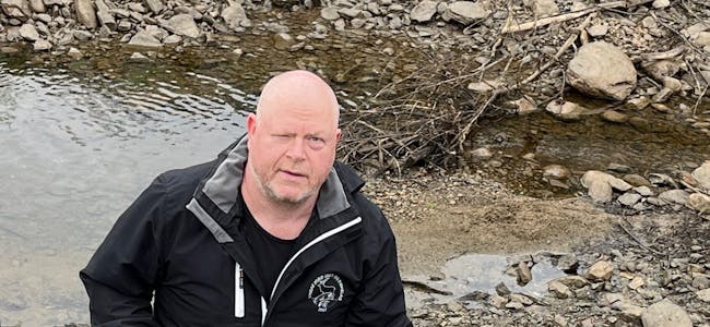 Leiar Nicolai Bastlien i Vindafjord Jakt- og Fiskelag med ein død fisk i elva frå ein større pytt i elva.