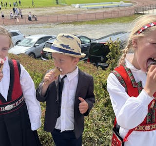 Agathe Ebbesvik Matre (f.v. 6), Oscar Ebbesvik Matre (4) og Live Serine Eljervik (7) er alle glade i jordbærkroneis, og koste seg under 17. mai-feiringa i Skånevik. Foto: Åse Hjelmervik