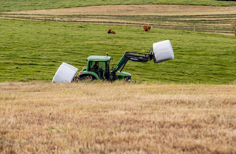 Ein traktor fraktar rundballar på ein åker ved Gammel-Kleppe i Vågåmo. I jordbruksoppgjeret får bøndene 10,9 milliardar kroner til auka inntekt og kostnadskompensasjon for 2022 og 2023. 
Foto: Stian Lysberg Solum / NTB / NPK