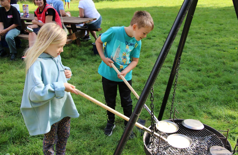 Sienna-Rose Thomas (7) og Hallvard Børretzen (6) lagar pannekaker på grillen.