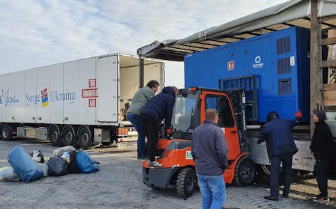 Eit aggregat på 200 kW blir lessa over frå Stiftelsen THK sin lastebil over i ein ukrainsk trailer ved grensa mellom Polen og Ukraina. Foto: Privat