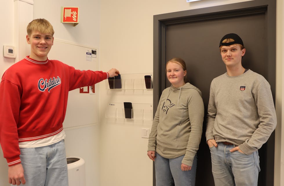 Theodor Vestbø Reimers (16) (t.v.), Mari Lyse (17) og Jakob Andreas Vedøy (18) ved Lundeneset vgs. legg mobilen i mobilboksen når timen tek til.